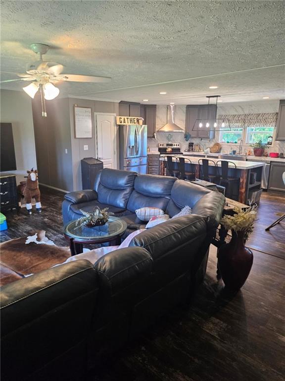 1292 255th St, Fort Scott, KS 66701 - living area with a textured ceiling, dark wood finished floors, and ceiling fan
