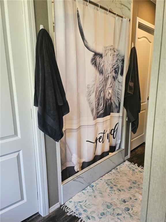 1292 255th St, Fort Scott, KS 66701 - full bathroom with wood finished floors and a shower with shower curtain