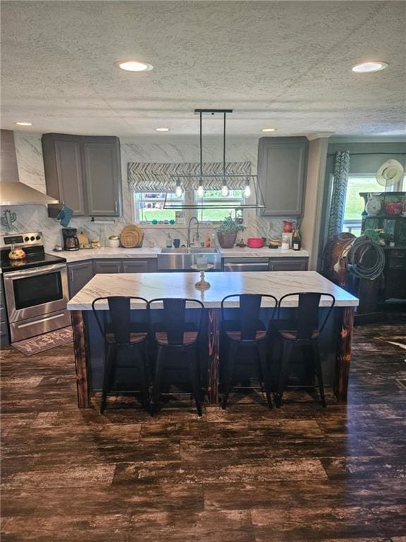 1292 255th St, Fort Scott, KS 66701 - kitchen featuring wall chimney range hood, stainless steel range with electric stovetop, a sink, light countertops, and dark wood-type flooring