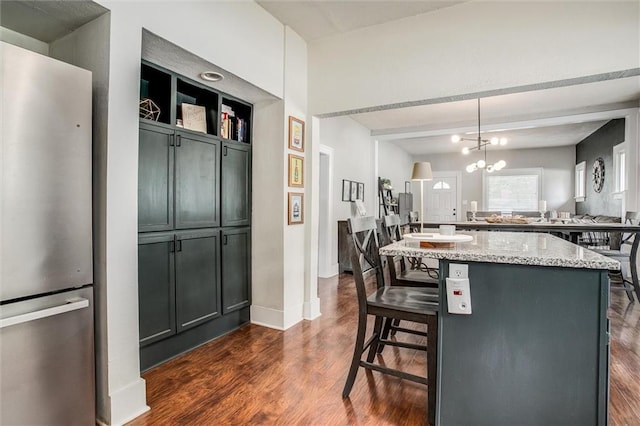 5818 W 75th St, Prairie Village, KS 66208 - kitchen with freestanding refrigerator, light stone counters, dark wood-style floors, and a breakfast bar