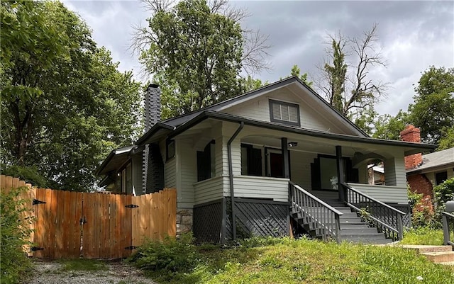 9400 E 17th St S, Independence, MO 64052 - view of front of home with a chimney, a porch, and stairway