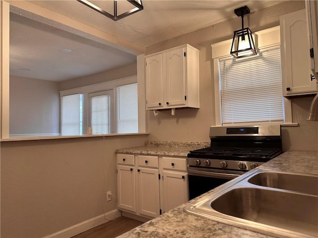 9400 E 17th St S, Independence, MO 64052 - kitchen with stainless steel range with gas stovetop, white cabinets, light countertops, and baseboards