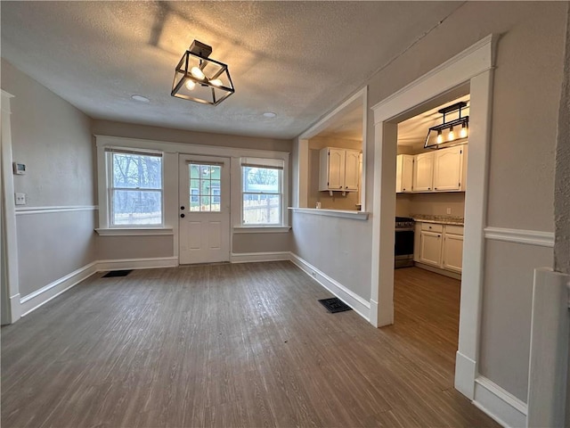 9400 E 17th St S, Independence, MO 64052 - foyer with dark wood-type flooring, a textured ceiling, and baseboards