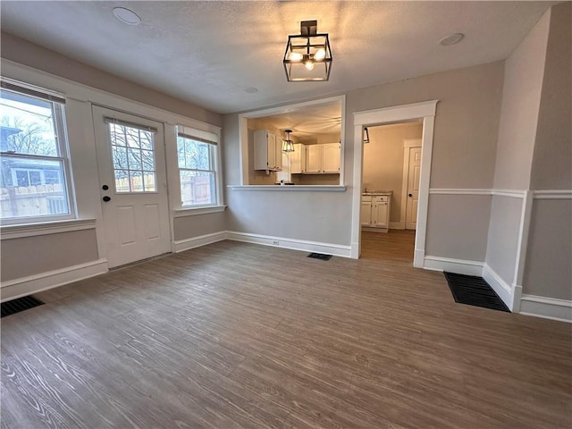 9400 E 17th St S, Independence, MO 64052 - unfurnished dining area featuring baseboards and dark wood-style flooring