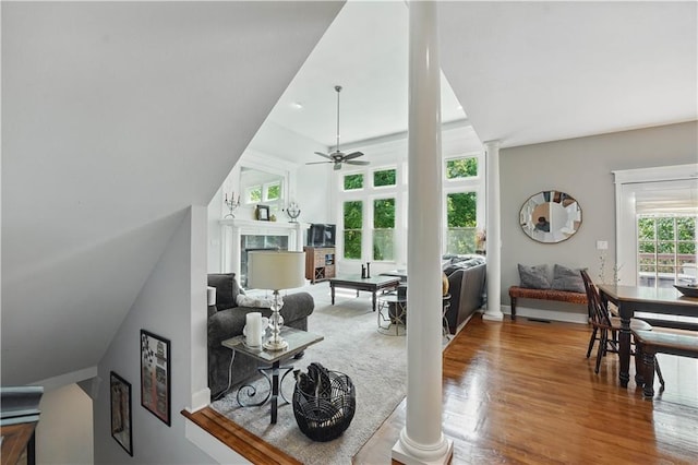 1040 Silverleaf Ln, Liberty, MO 64068 - living area featuring ceiling fan, wood finished floors, decorative columns, a fireplace, and vaulted ceiling