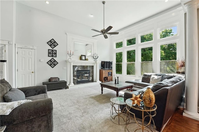 1040 Silverleaf Ln, Liberty, MO 64068 - living room with a ceiling fan, ornate columns, a tile fireplace, and a high ceiling