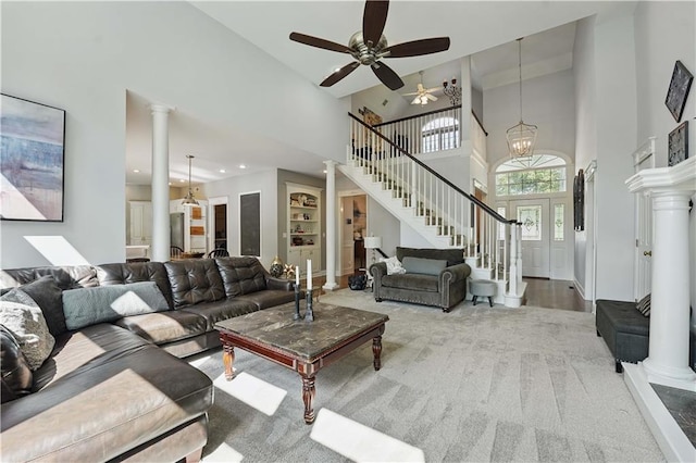 1040 Silverleaf Ln, Liberty, MO 64068 - living room with a towering ceiling, ornate columns, stairway, a ceiling fan, and carpet