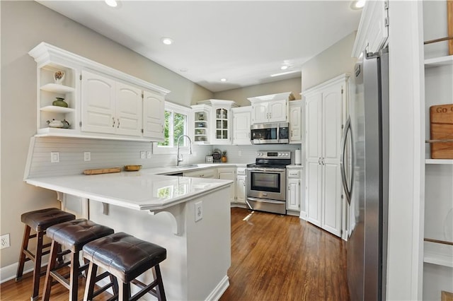 1040 Silverleaf Ln, Liberty, MO 64068 - kitchen with stainless steel appliances, a peninsula, a sink, a breakfast bar, and open shelves
