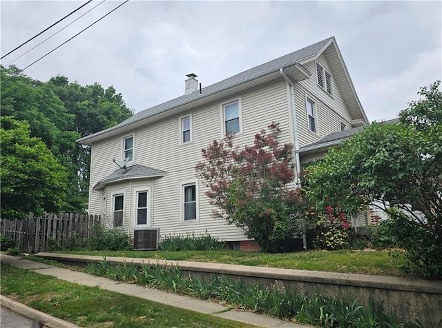 view of front of property with central AC unit and a chimney