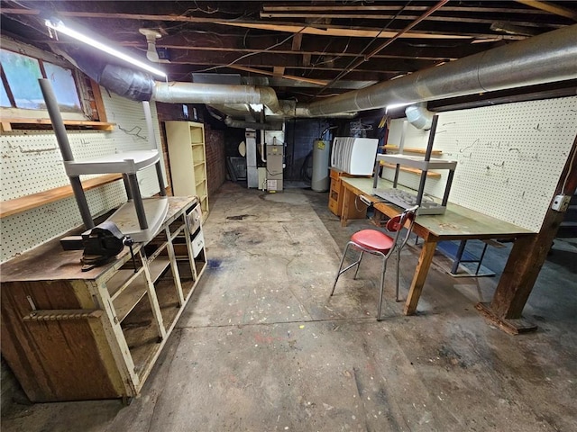 unfinished basement featuring a workshop area, water heater, and heating unit
