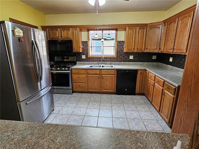kitchen featuring black appliances, a sink, tasteful backsplash, and brown cabinets