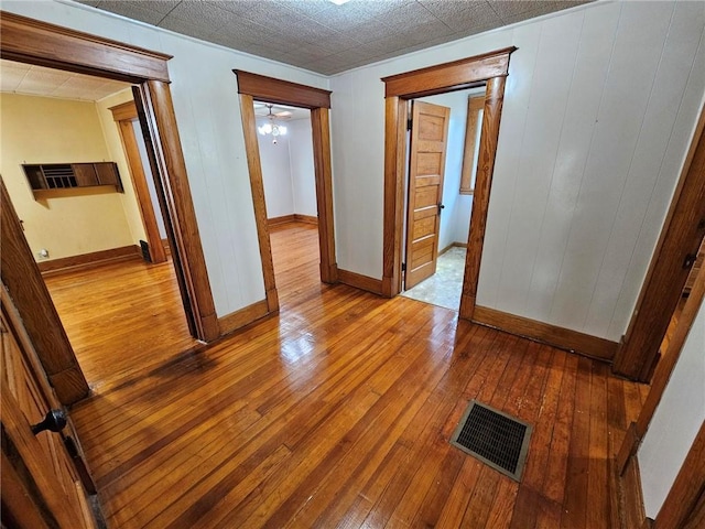 unfurnished room with hardwood / wood-style floors and baseboards