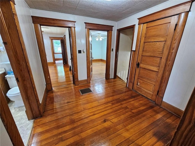 hallway with hardwood / wood-style floors and baseboards
