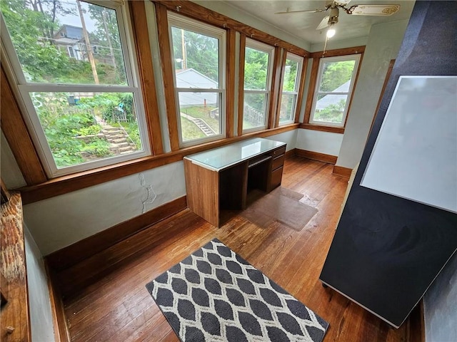 unfurnished sunroom with baseboards, hardwood / wood-style flooring, and plenty of natural light