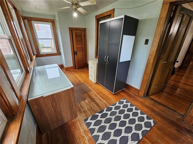 office area featuring wood finished floors, baseboards, and ceiling fan