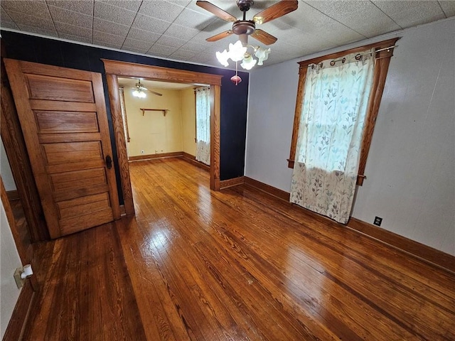 spare room featuring hardwood / wood-style flooring, ceiling fan, and baseboards