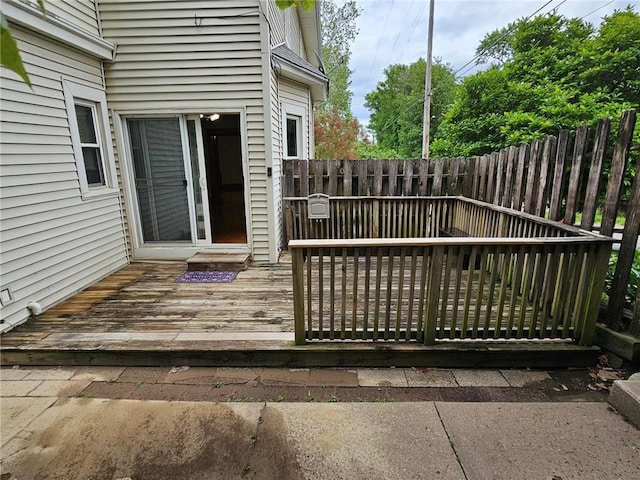 wooden terrace with a fenced backyard