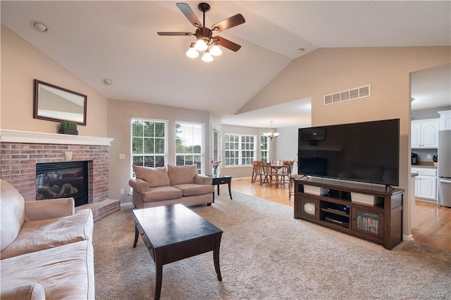 3100 Clarendon Rd, Sedalia, MO 65301 - living area with lofted ceiling, ceiling fan, a fireplace, a chandelier, and light colored carpet