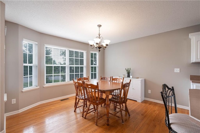 3100 Clarendon Rd, Sedalia, MO 65301 - dining space featuring a chandelier, light wood-style floors, baseboards, and a textured ceiling