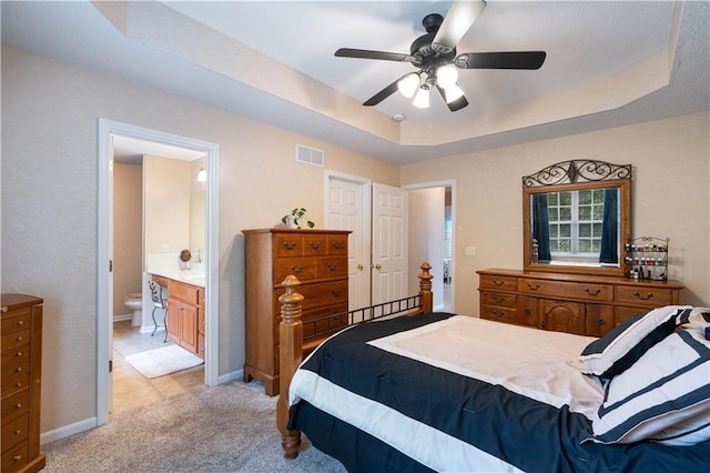 3100 Clarendon Rd, Sedalia, MO 65301 - bedroom featuring light colored carpet, a tray ceiling, ensuite bath, baseboards, and a ceiling fan