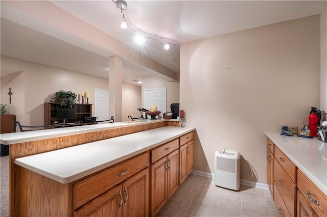 3100 Clarendon Rd, Sedalia, MO 65301 - kitchen with a peninsula, light countertops, brown cabinets, and light tile patterned flooring