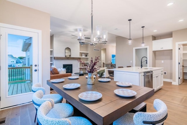 16729 Pinehurst Dr, Basehor, KS 66007 - dining room featuring light wood-style floors, recessed lighting, a chandelier, a large fireplace, and baseboards