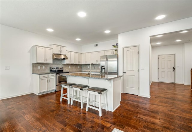 23713 W 88th St, Lenexa, KS 66227 - kitchen featuring stainless steel appliances, under cabinet range hood, a breakfast bar area, dark wood-style floors, and decorative backsplash