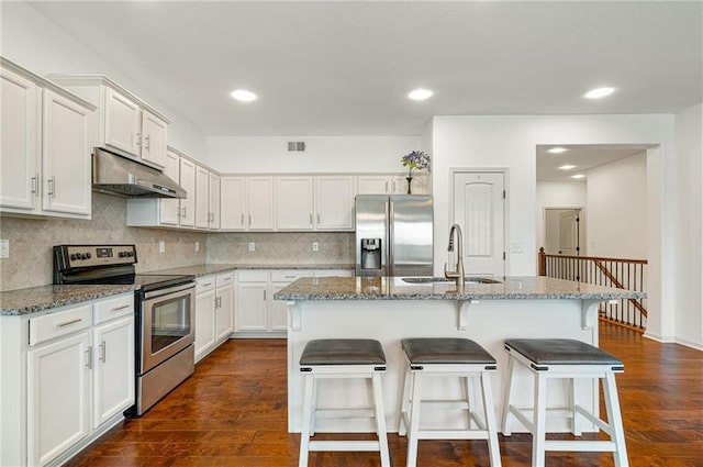 23713 W 88th St, Lenexa, KS 66227 - kitchen with appliances with stainless steel finishes, under cabinet range hood, a sink, dark wood-style floors, and a breakfast bar area