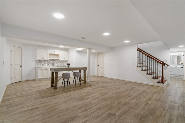 23713 W 88th St, Lenexa, KS 66227 - kitchen with white cabinetry, light wood-type flooring, recessed lighting, baseboards, and tasteful backsplash