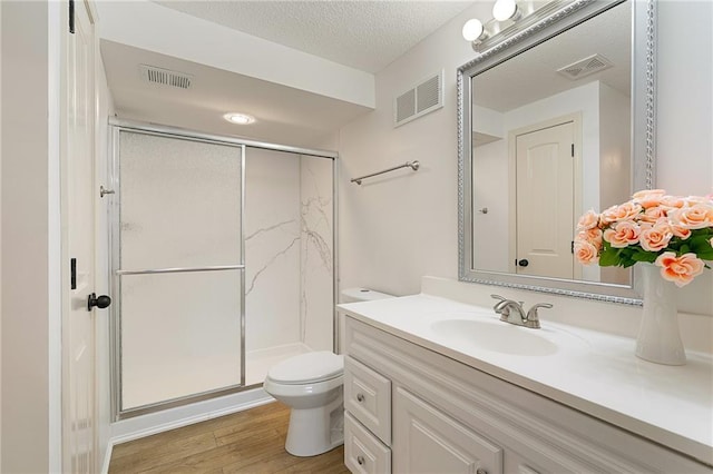 23713 W 88th St, Lenexa, KS 66227 - full bath featuring toilet, vanity, a shower stall, wood finished floors, and a textured ceiling