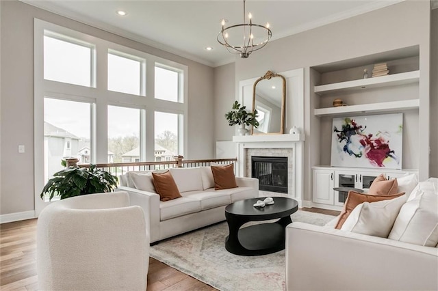 15670 W 165th Ter, Olathe, KS 66062 - living area with crown molding, a chandelier, a brick fireplace, light wood-type flooring, and baseboards