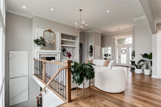 15670 W 165th Ter, Olathe, KS 66062 - living room featuring a chandelier, crown molding, wood finished floors, a fireplace, and recessed lighting