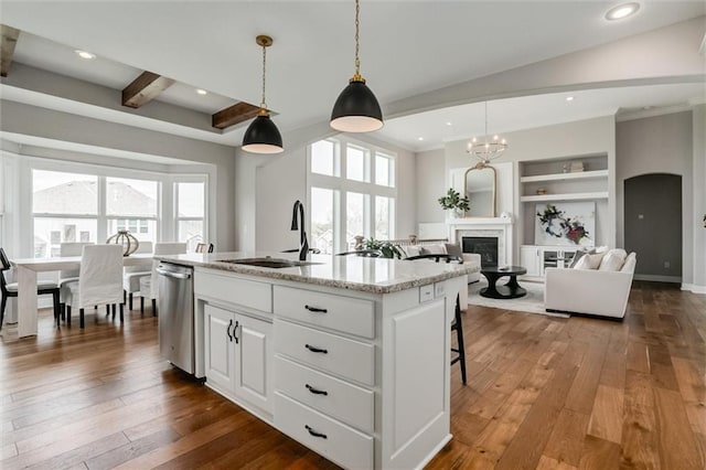 15670 W 165th Ter, Olathe, KS 66062 - kitchen with a sink, stainless steel dishwasher, dark wood-type flooring, a glass covered fireplace, and beam ceiling