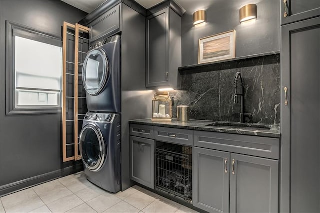 15670 W 165th Ter, Olathe, KS 66062 - laundry area featuring stacked washer / drying machine, cabinet space, and light tile patterned floors