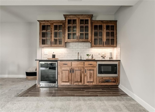 15670 W 165th Ter, Olathe, KS 66062 - indoor wet bar featuring beverage cooler, black microwave, baseboards, and backsplash
