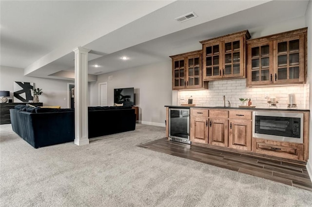 15670 W 165th Ter, Olathe, KS 66062 - indoor wet bar featuring built in microwave, tasteful backsplash, dark carpet, beverage cooler, and baseboards