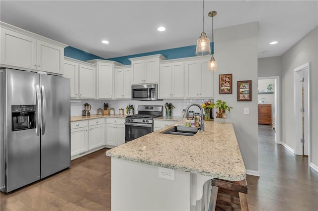 1302 N 159th St, Basehor, KS 66007 - kitchen with stainless steel appliances, a peninsula, a sink, white cabinetry, and a kitchen breakfast bar