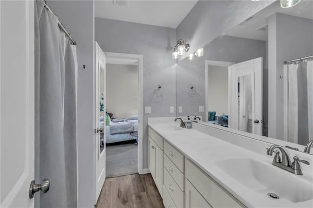 1302 N 159th St, Basehor, KS 66007 - bathroom with connected bathroom, double vanity, and wood finished floors