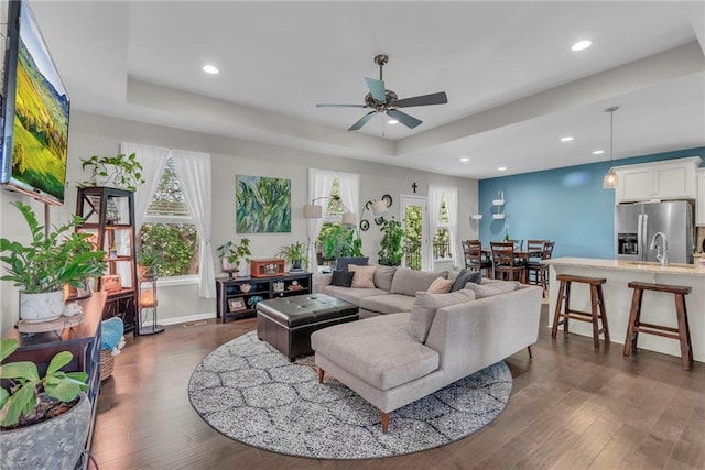 1302 N 159th St, Basehor, KS 66007 - living room with a ceiling fan, dark wood-style flooring, recessed lighting, baseboards, and a tray ceiling