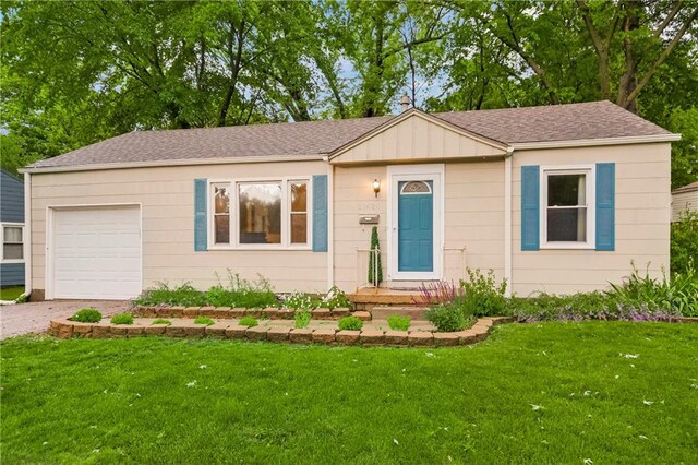 11424 W 67th Ter, Shawnee, KS 66203 - view of front facade with a garage, driveway, a front yard, and board and batten siding