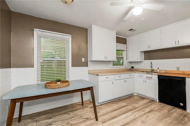 11424 W 67th Ter, Shawnee, KS 66203 - kitchen with black dishwasher, a sink, light countertops, wainscoting, and white cabinets