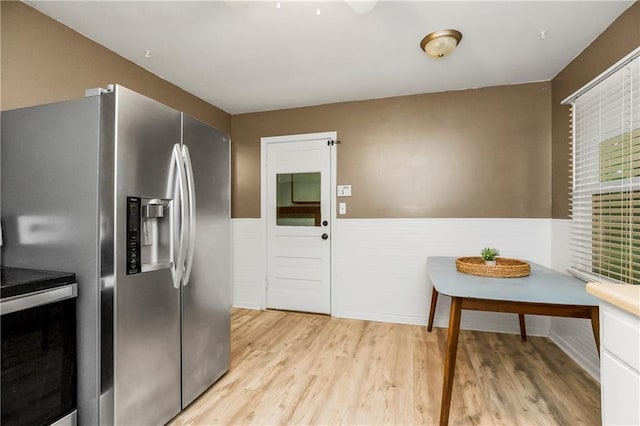 11424 W 67th Ter, Shawnee, KS 66203 - kitchen with stainless steel appliances, a wainscoted wall, and light wood-style flooring