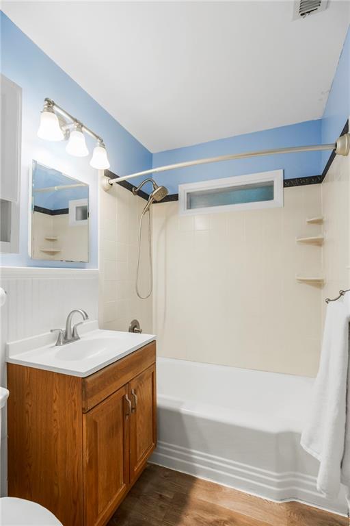 11424 W 67th Ter, Shawnee, KS 66203 - bathroom featuring toilet, vanity,  shower combination, and wood finished floors