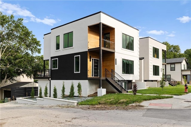 4550 Bell St, Kansas City, MO 64111 - view of front of home featuring a balcony, stucco siding, and stairway