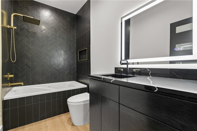 4550 Bell St, Kansas City, MO 64111 - full bath with vanity, tiled shower / bath combo, and wood finished floors