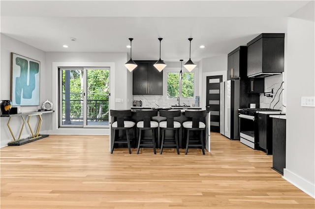 4550 Bell St, Kansas City, MO 64111 - kitchen with range with gas cooktop, dark cabinets, a kitchen breakfast bar, freestanding refrigerator, and recessed lighting