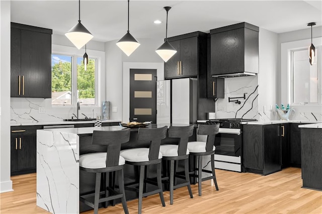 4550 Bell St, Kansas City, MO 64111 - kitchen featuring dark cabinets, range with gas cooktop, tasteful backsplash, and recessed lighting