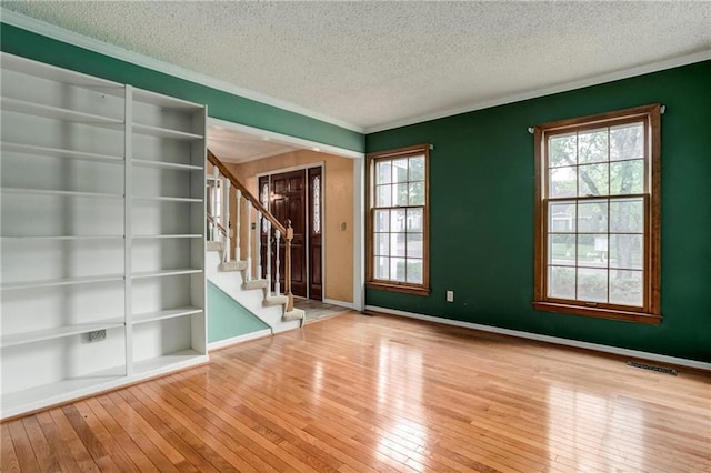 10404 Flint St, Overland Park, KS 66214 - unfurnished room featuring hardwood / wood-style flooring, a textured ceiling, stairs, crown molding, and baseboards