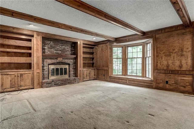 10404 Flint St, Overland Park, KS 66214 - unfurnished living room featuring a textured ceiling, built in features, beam ceiling, carpet, and wood walls