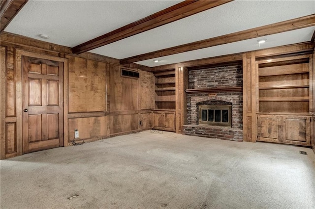 10404 Flint St, Overland Park, KS 66214 - unfurnished living room with beam ceiling, carpet flooring, a fireplace, a textured ceiling, and built in features